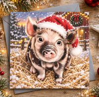 Piglet Christmas card featuring a cute brown and pink pig wearing a red Santa hat in the snow