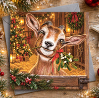 Goat Christmas card featuring a cheeky brown and white goat holding a sprig of mistletoe