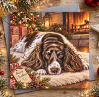Springer Spaniel Christmas card featuring a beautiful liver and white dog resting by a glowing fireplace with a Merry Christmas gift tag.