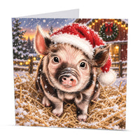 Square farm animal Christmas card featuring a little pig in a Santa hat surrounded by snow and golden straw
